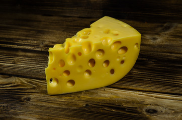 Piece of cheese on wooden table