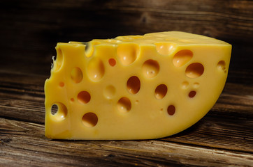 Piece of cheese on wooden table