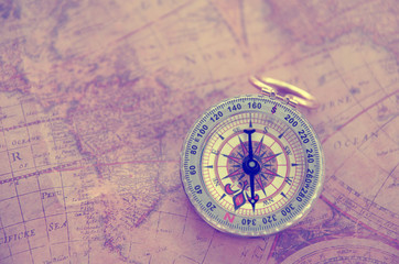 Fototapeta na wymiar Old vintage retro golden compass on ancient map