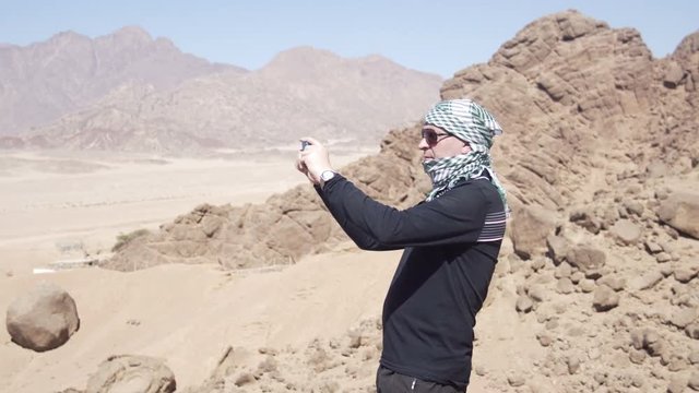 Man in the desert takes photo of dune