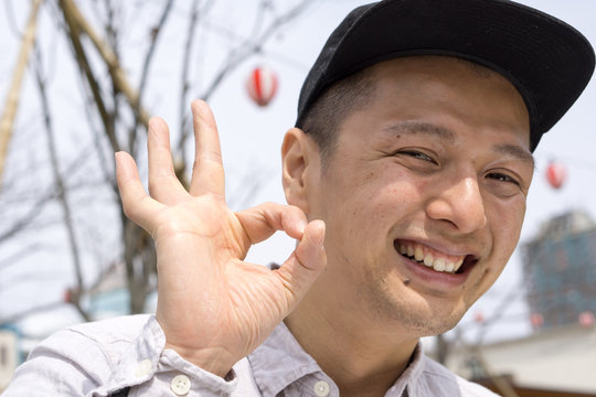 おもしろポーズで感情表現をするキャップ姿の日本人男性｜SNS・YouTubeサムネ向けストックフォト