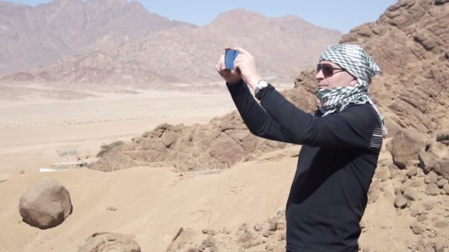 Man in the desert takes photo of dune
