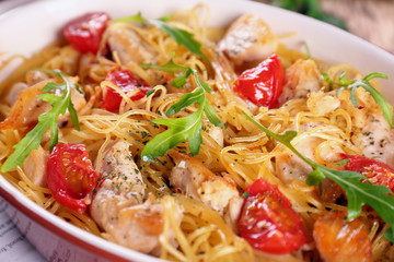 Delicious spaghetti with chicken, tomatoes and arugula in baking dish