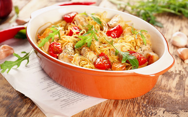 Baking dish with delicious chicken spaghetti on table