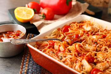 Baking dish with delicious chicken spaghetti on table