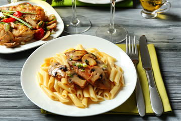 Tasty chicken marsala with pasta on table