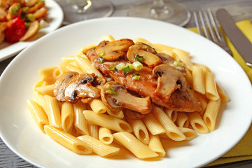 Tasty chicken marsala with pasta on table