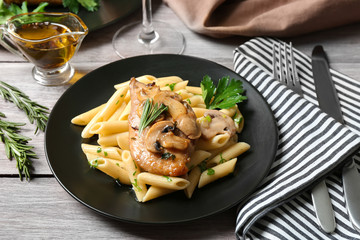 Tasty chicken marsala with pasta on table