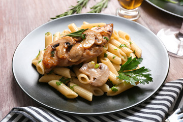Tasty chicken marsala with pasta on table