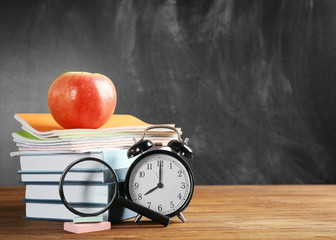 Books and alarm clock on blackboard background © Africa Studio