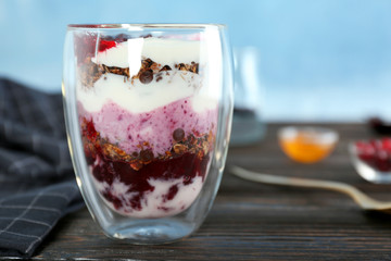 Delicious dessert with berry jam in glass on table
