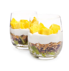 Delicious dessert with mango in glasses on white background