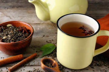 Cup of aromatic tea on wooden background