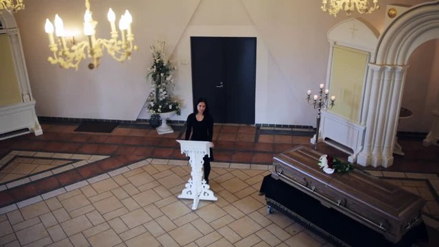 sad woman and coffin at funeral in orthodox church