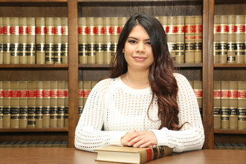 Young attractive female law student in law library