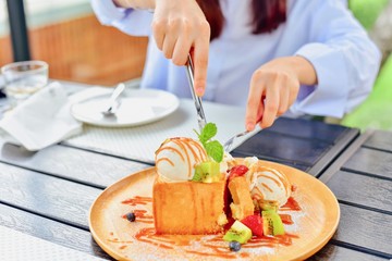 Close-Up of a Woman's Hands Cutting a Portion of Honey Toast