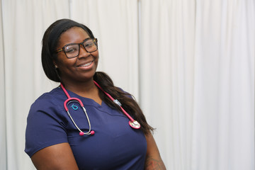 Portrait of a happy African American female healthcare professional, portrait of a nurse with stethoscope