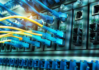 Fiber Optic cables connected to an optic ports and Network cables connected to ethernet ports