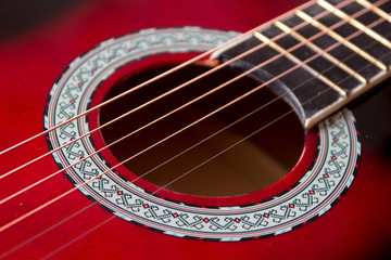 Obraz premium Part of red acoustic guitar. Close up