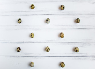 Pattern with quail eggs on white wooden vintage table. Flat lay, top view