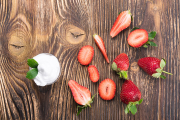 red strawberry with cream on a dark board