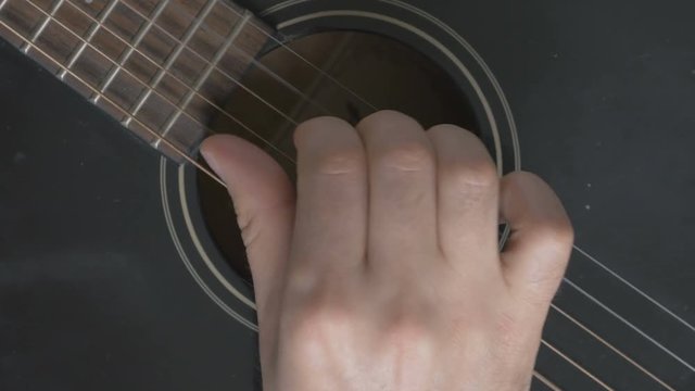 Guitar strings closeup. A man plays gitare