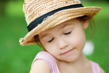 Girl in a straw hat in the park