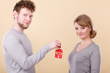 Couple holding key with house symbol