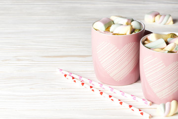 Two pink cup with cocoa and marshmallow