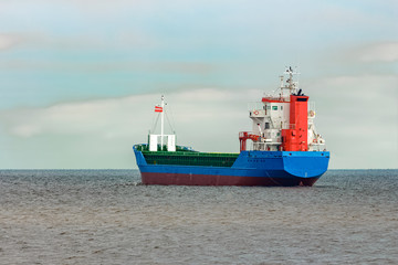 Blue cargo ship entering the Baltic sea. Riga, Europe