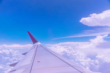 Fototapeta na wymiar Wing of an airplane above white clouds.