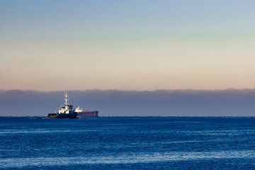 Blue small tug ship leaving Riga and entering the Baltic sea