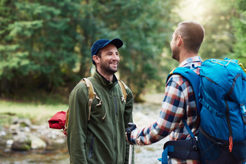 Two smiling hikers talking together in the wilderness