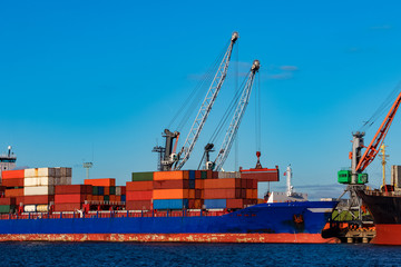 Fototapeta premium Blue container ship loading in cargo port of Europe