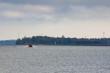 Red pilot ship moving at speed to Baltic sea. Riga, Europe