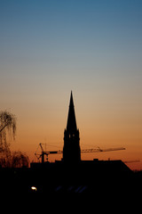 Obraz premium Sunset silhouette, church and crane