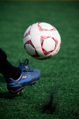 Soccer ball mid-kick with foot