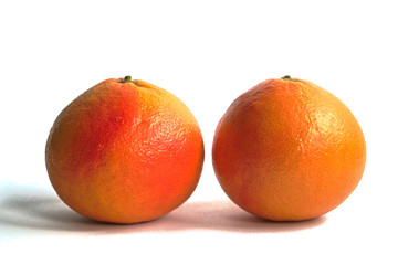 Two red grapefruits on a white background