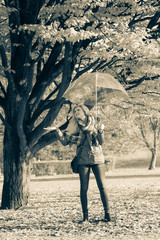 Woman walking in park with umbrella