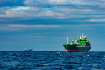 Fototapeta premium Green cargo ship moored in still Baltic sea water