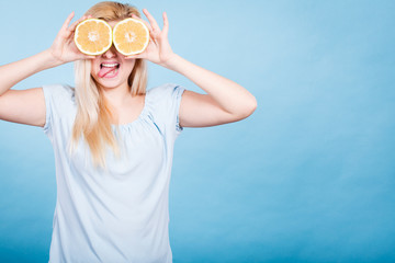 Girl covering her eyes with grapefruits