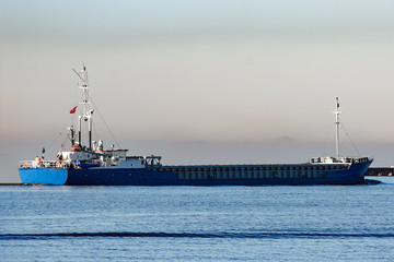Blue cargo ship leaving Riga and entering Baltic sea