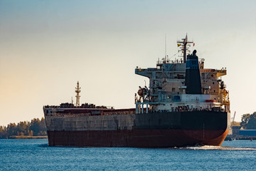 Black cargo ship entering Riga, Europe