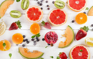 Fresh mixed fruits on white wooden table.