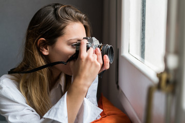 Woman with camera shooting window