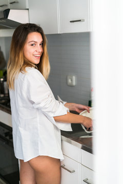 Cheerful woman washing dishes