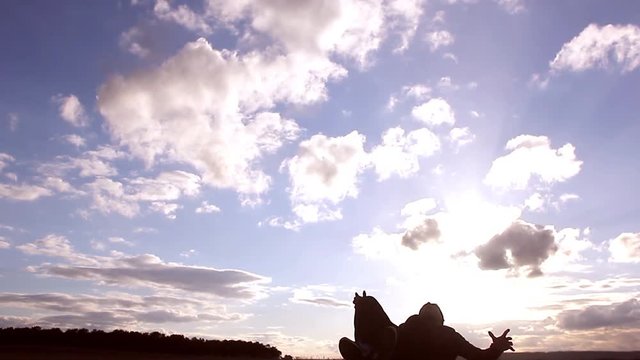 Beautiful sunset and silhouettes of men playing football, kick a soccer ball, goalkeeper catches ball. Silhouette of soccer player ready to execute penalty kick on the field.