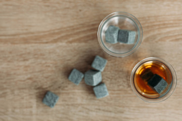 Stones for cooling whiskey and glases tulup on light wooden background