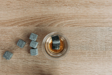 Stones for cooling whiskey and glases tulup on light wooden background