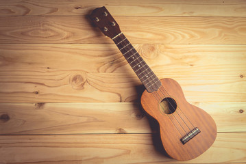 Fototapeta premium Close up of ukulele on old wooden background , vintage